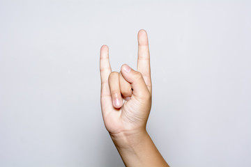 Boy hand show the Rock and Roll sign or devil horns gesture on a white background.
