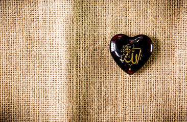 Heart shape stone with Arabic script on burlap 