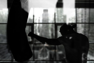 Boxer hits a punching bag against the window, training