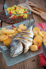 bream baked with lemon roasted potatoes and vegetables in glass