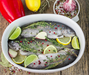 Three raw rainbow trout with spices