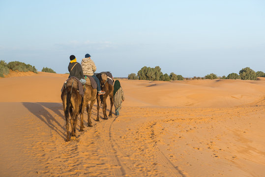 The arabian guide with couple of tourist in Sahara desert