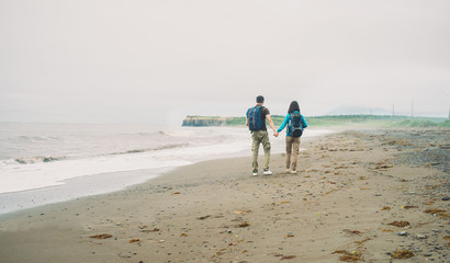 Hiker couple walking on beach