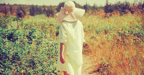 Fototapeta na wymiar Fashionable young woman walking in summer park