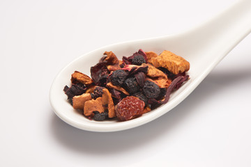 Heap of dry fruit tea in white ceramic spoon
