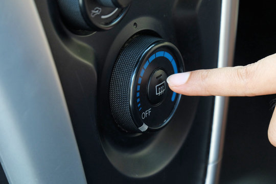 Finger pressing car defrost button