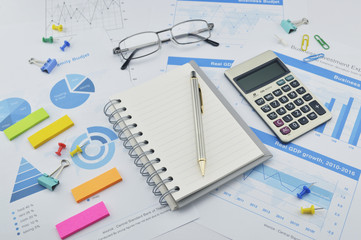 Naklejka na ściany i meble Pen, calculator and notebook on financial chart and graph, accou