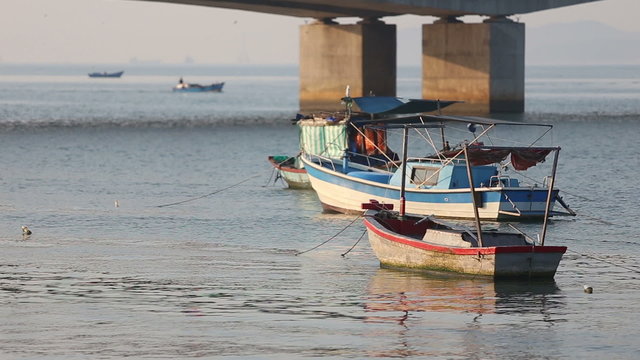 vietnamese fishing boats roll on river near bridge in vietnamese city at dawn