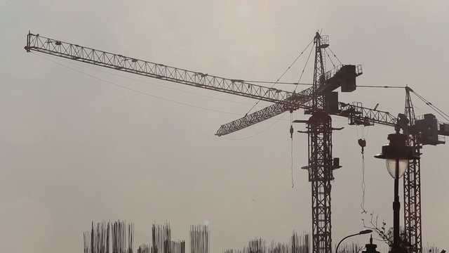 panorama of cranes over building construction at dawn