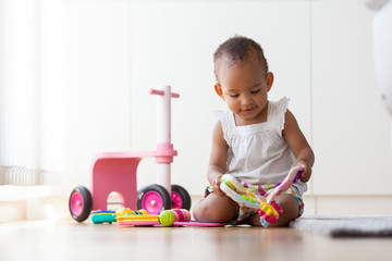 Portrait of little African American little girl sitting on the f