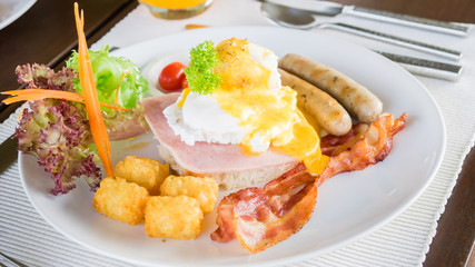 Egg benedict  on ham with bacon, sausage and vegetable for breakfast.