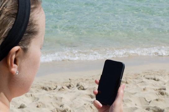 Ragazza scrive e-mail in riv aal mare con la connessione wireless