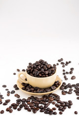 Cup full of coffee beans on on white background