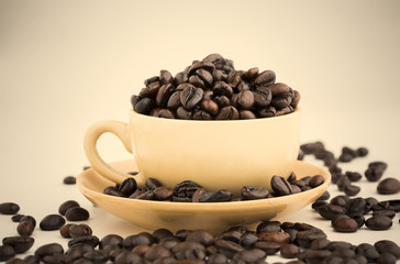 Cup full of coffee beans on on white background