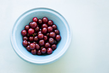 Fresh cherries in bowl on table