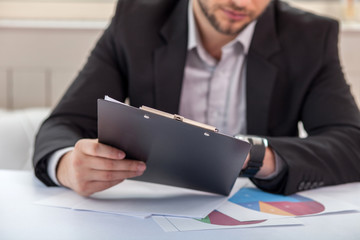 Handsome young man is checking his sketches