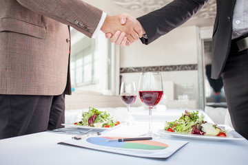 Successful businessmen are signing a contract in restaurant