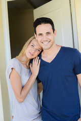 Naklejka premium happy young couple man and woman opening door of their new home entrance