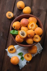 Ripe organic apricots, dark brown wooden background, top view
