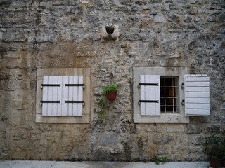 white shutters and medieval stone wall on old town Budva