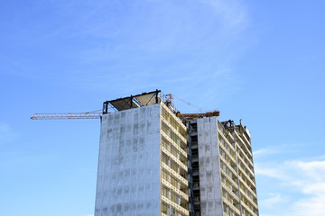 Fototapeta na wymiar demolition of a skyscraper with a high crane