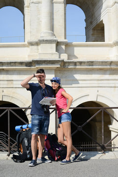 cheerful young couple backpacker traveling and sighseeing in europe during summer