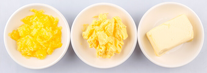 A block of butter, margarine and ghee in white bowls  - obrazy, fototapety, plakaty