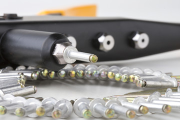 black rivet pliers and rivet on white background