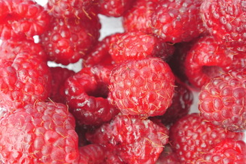 Closeup of a pile of ripe red juicy raspberries. Healthy/clean eating concept; paleo diet.