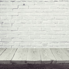 Empty wooden table over white brick wall background
