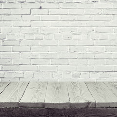 Empty wooden table over white brick wall background
