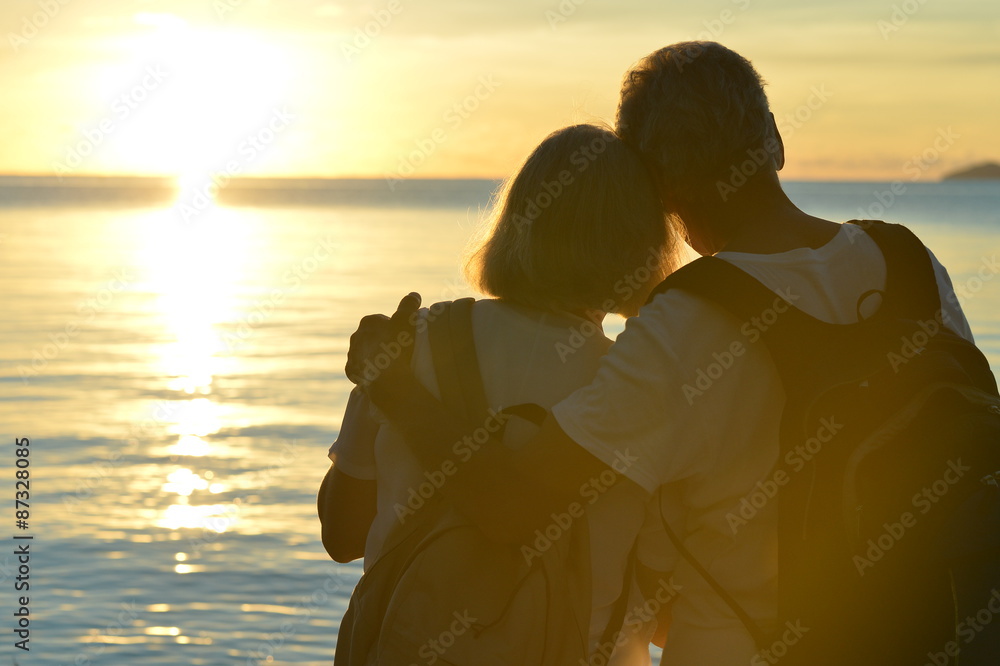 Wall mural Senior couple at sea at sunset