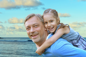 Father with daughter against the sea