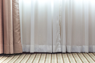 Light shines through white curtains in room