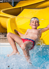 child playing with the slide in the pool