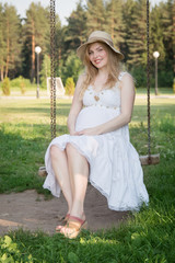 Pregnant woman sitting on a swing
