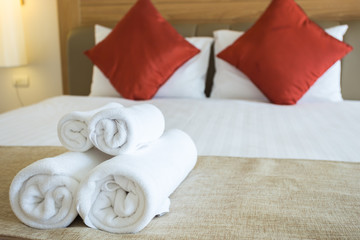 Fototapeta na wymiar Close up of nice towels on white bed sheet with red pillow