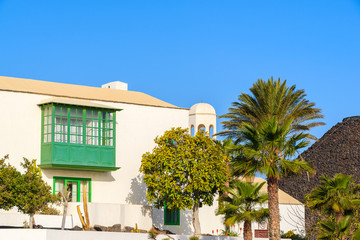 Fototapeta na wymiar Typical Canary style house with green balcony in Playa Blanca town, Lanzarote island, Spain