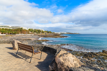 Bench on promenade along ocean coast in Playa Blanca, Lanzarote, Canary Islands, Spain