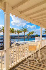 Chairs on terrace in Puerto Calero marina built in Caribbean style, Lanzarote, Canary Islands, Spain