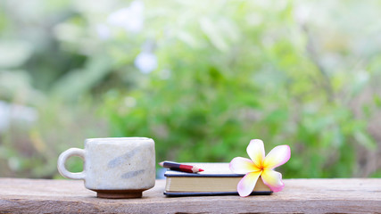 Notebook  and coffee in old cup on wooden table