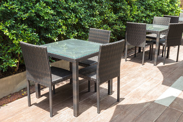 Fototapeta premium Cafe tables and chairs outside with green plant