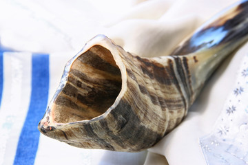 shofar (horn) on white prayer talit. jewish holiday concept