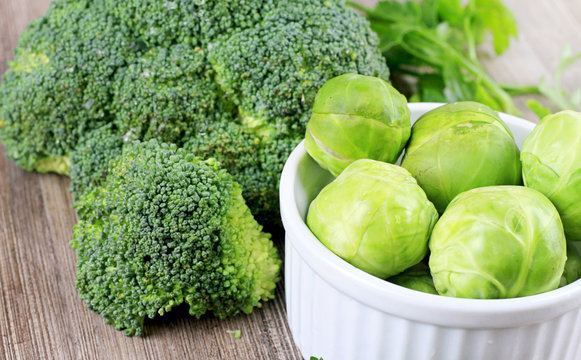 Brussels sprouts and broccoli, fresh vegetables on wooden background