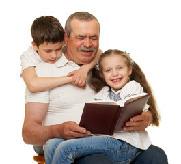 Grandfather and grandchildren read book