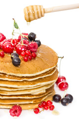 Pile of pancakes with berries and honey