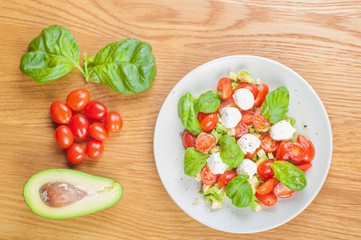 Top view to the salad with avocado and tomatoes