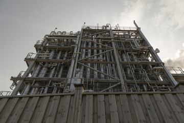 A fence and a lot of pipes on a factory building