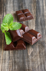 pieces of chocolate with mint lying on a wooden