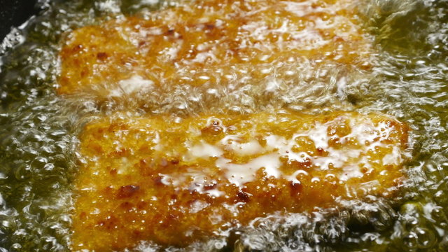 Fish corners cooking in a frying pan. 4k footage.
